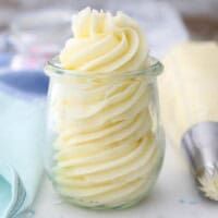 a jar filled with whipped cream sitting on top of a table next to a spoon