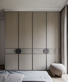 a bed sitting next to a tall wooden cabinet with two doors on it's sides