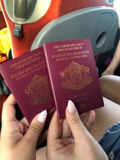 two people are holding their passports in their hands