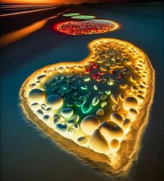 an art installation made out of rocks and pebbles in the shape of a heart at night