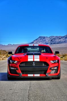 a red sports car with white stripes on the front