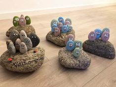 four rocks with faces on them are sitting on the floor next to each other,