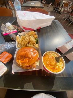 there is a sandwich and some fries on the table in front of it, along with other food items