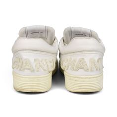 Chanel low-top sneakers in white leather with perforated side seam panels, thick cream rubber soles, and a raised logo across the back heel in white terrycloth. Brand = Chanel Size = Women's 39 EU Condition = Great. Light wear to toes, some discolouration in rubber soles Material = Leather SKU = 23095-44 Top Sneakers Women, Sneaker Collection, Men's Collection, Dress With Boots, Resort Wear, Loafer Shoes, White Leather, Low Top, Mini Bag