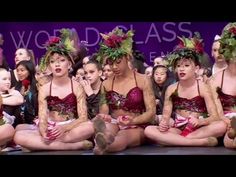 a group of young women sitting on top of each other in front of a stage