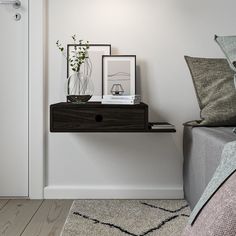 there is a shelf with pictures on it next to a bed and pillows in the room