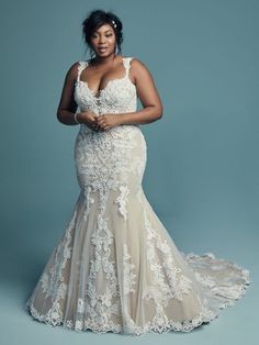 a woman in a wedding dress posing for the camera with her hands on her hips