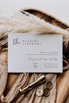 the wedding stationery is laid out on top of a fur - lined coat and tie