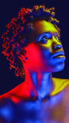 a woman with blue and red light painted on her face, looking to the side