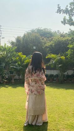 a woman standing on top of a lush green field