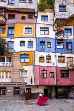 a woman standing in front of a multicolored building