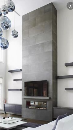 a living room filled with furniture and a flat screen tv mounted on a wall next to a fire place