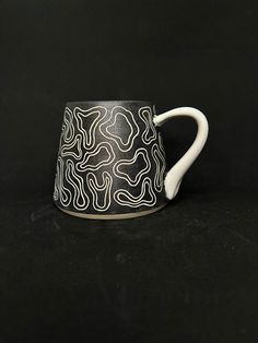 a black and white coffee cup on a black background