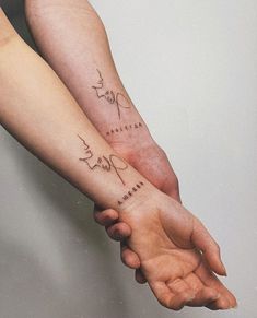 two people holding hands with tattoos on their arms and the words love are written in cursive writing