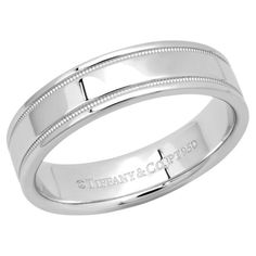 a white gold wedding band with engraved engraving on the outside and inside, set in 18k white gold