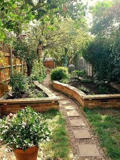 an outdoor garden with stone walkways and potted plants on the side of it