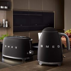 two black toasters sitting on top of a counter next to each other in a kitchen