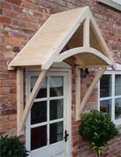 an outside view of a house with windows and a wooden awning over the door