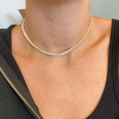 We took everyone’s favorite, the Tennis Choker, and enhanced the design. Adorn your neck with this gold-plated spectacular stunner. This sophisticated Tennis Choker is custom-cut in sleek crystal clear cubic zirconia 4mm stones. The delicate yet durable clasp fits perfectly on your collarbone because it comes in adjustable sizing. This tennis choker will take you everywhere from day to night. Designed to perfection in Montreal, Canada. All our products are of high quality, long-lasting, and resi Gold Tennis Necklace With Rhinestones, Gold Tennis Necklace With Rhinestones And Cubic Zirconia, Elegant Iced Out Tennis Necklace For Anniversary, Elegant White Iced Out Tennis Necklace, Luxury Diamond Tennis Necklace With Rhinestones, Gold Cubic Zirconia Tennis Necklace For Anniversary, Luxury Cubic Zirconia Tennis Necklace With Rhinestones, Gold Crystal Tennis Necklace With Sparkling Stones, Gold Crystal Tennis Necklace For Anniversary