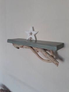 a wooden shelf with two white starfish on it and one is made out of driftwood