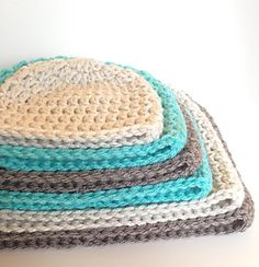 four crocheted dishcloths stacked on top of each other in different colors