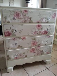 a white dresser with pink flowers painted on it