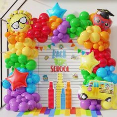 a school bus and balloon arch for a back to school party with balloons on the wall