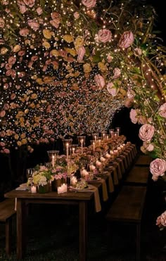 a long table with candles and flowers on it is set up for an outdoor dinner