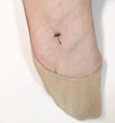 a small dandelion tattoo on the ankle