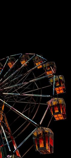 the ferris wheel is lit up at night