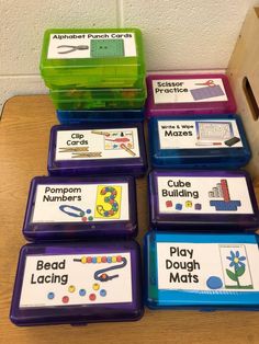 several plastic containers with matching pictures on them sitting on a table next to a wooden box