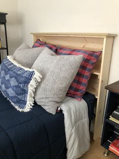 a bed with several pillows on top of it and a night stand next to it