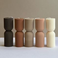 five different colored vases sitting on top of a white table next to each other