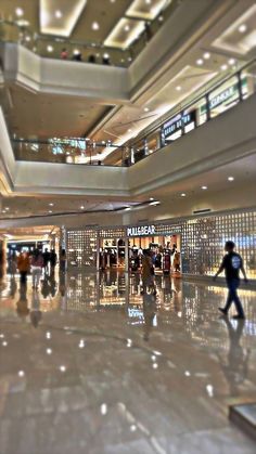 people are walking through an airport lobby