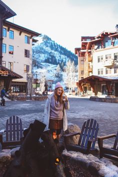 a woman standing in front of a fire pit