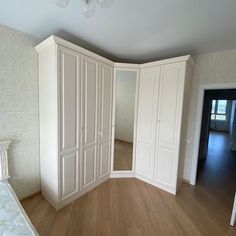 an empty bedroom with white closets and wood floors