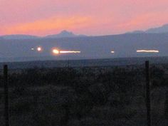 an airplane is flying over the mountains at sunset or dawn in the distance, with another plane on the horizon