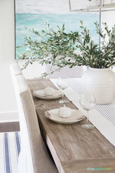 a dining room table with plates and glasses on it