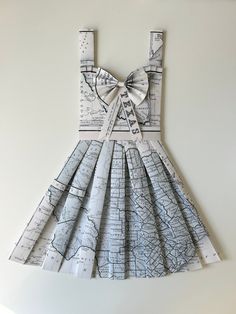 a dress made out of maps with a bow on the front and straps at the back