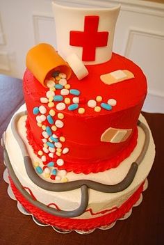 a red cake with white and blue sprinkles on it, topped with a medical hat