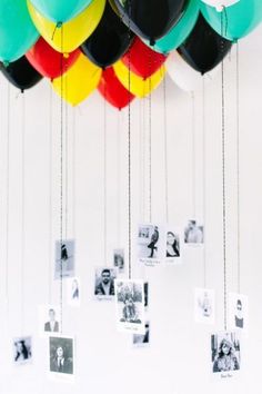 many balloons are hanging from strings with photos attached to them