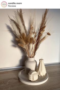 there is a white vase with dried plants in it