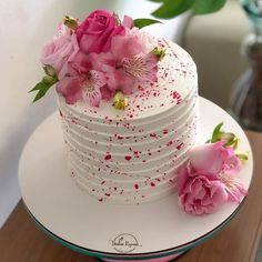 there is a white cake with pink flowers on it