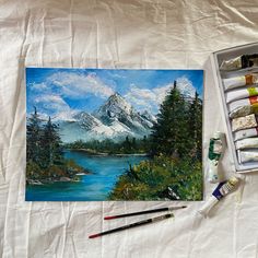 a painting with watercolors and paintbrushes next to it