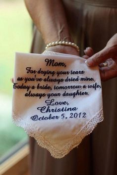 a woman holding a white handkerchief with the words mom on it and an embroidered message