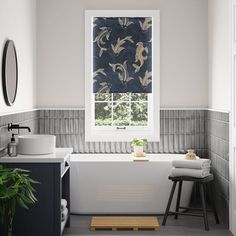 a white bath tub sitting under a window next to a sink