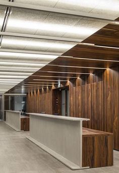 an empty office with wood paneling on the walls and counter tops in front of it