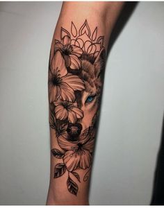 a woman's arm with flowers and a wolf on it