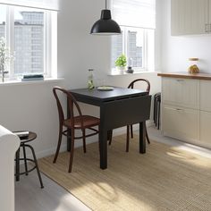 a kitchen table with two chairs in front of it, and a window behind it