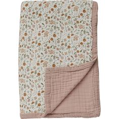 a blanket with flowers on it and a pink lining around the edges is folded in front of a white background